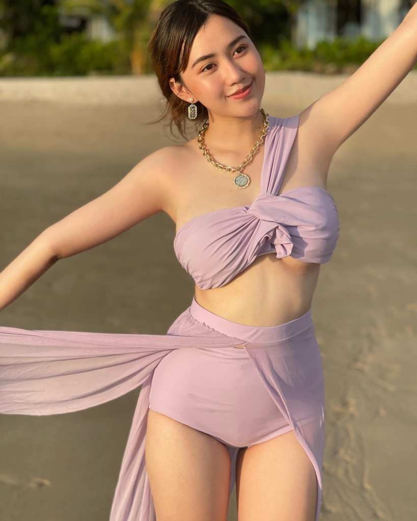 Sweet beach-going Thai lady in purple outfit